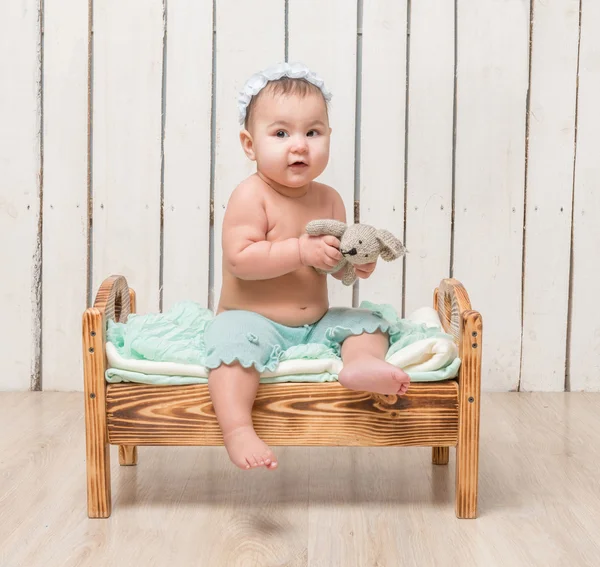 Kleines Kind sitzt auf Kinderbett — Stockfoto