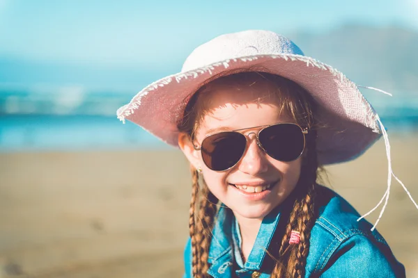 Liten flicka i en hatt på stranden — Stockfoto