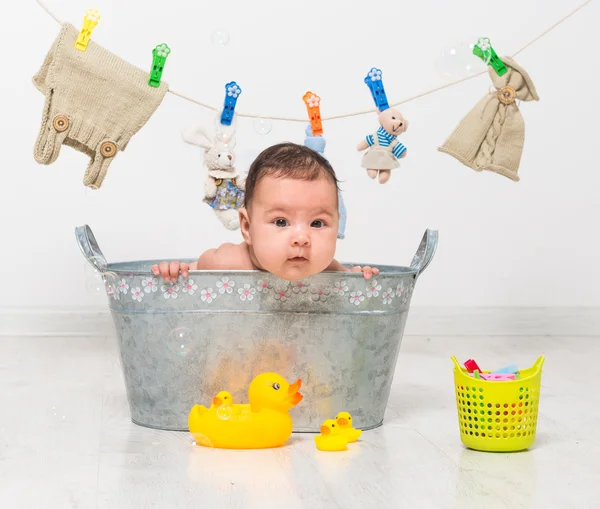 Baby flicka badar i ett tråg — Stockfoto