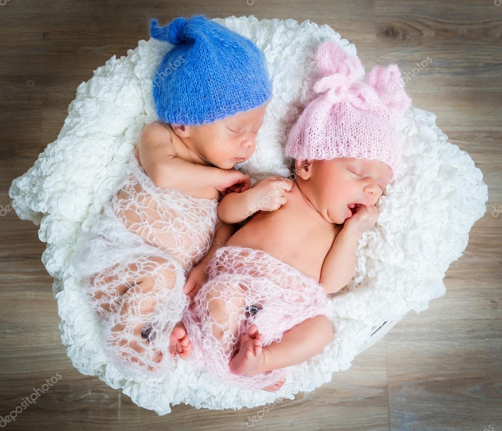 newborn twins l sleeping in a basket