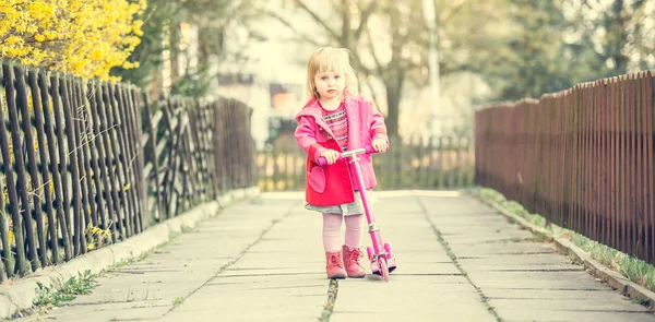 Anno-vecchia ragazza cavalcando il suo scooter — Foto Stock