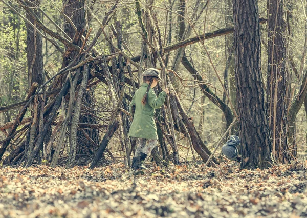 Ittle cute girl builds a hut in the woods — Stock Photo, Image