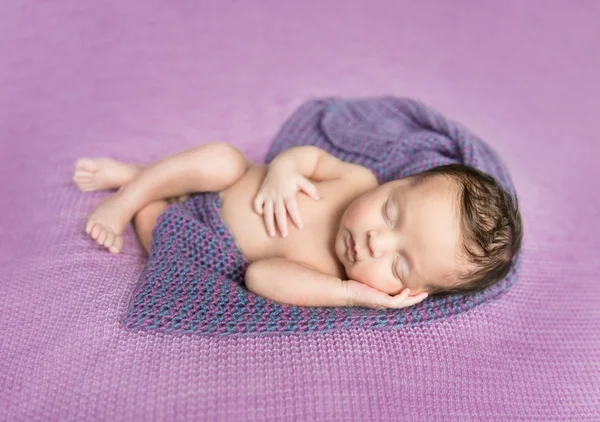 Bebê recém-nascido dormindo em um cobertor roxo — Fotografia de Stock