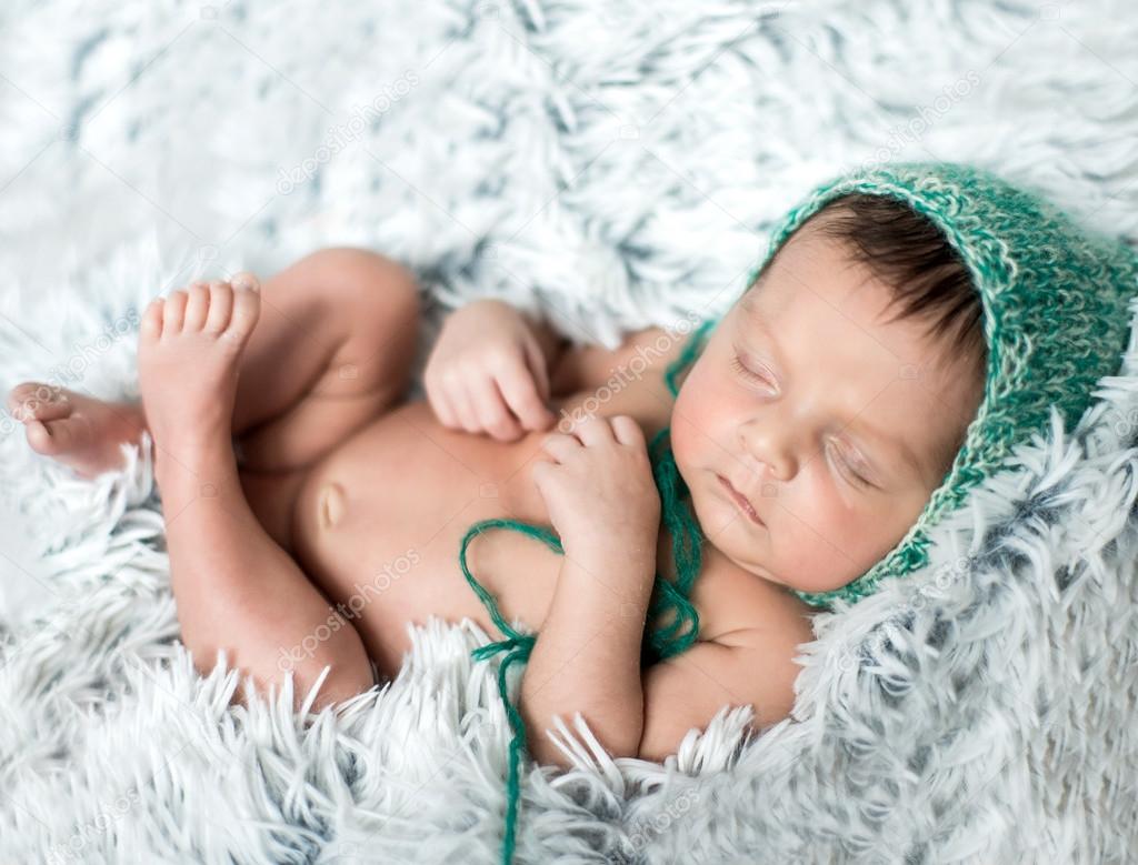 newborn boy sleeping on grey blanket