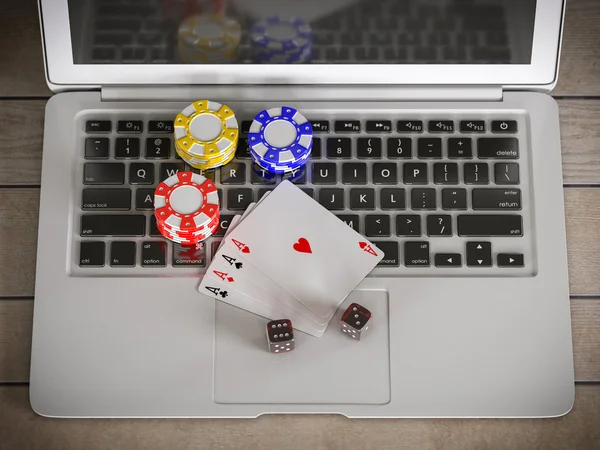 Laptop com fichas, dados e cartões de poker — Fotografia de Stock