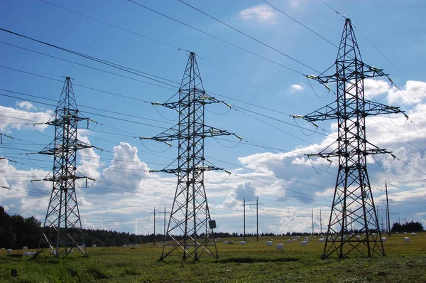 Lignes électriques à haute tension au-dessus du champ de blé, Centrale électrique sur le terrain dans un ciel nuageux bleu — Photo