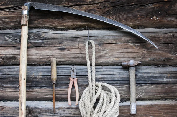 Vecchi utensili arrugginiti su parete di legno su fienile — Foto Stock