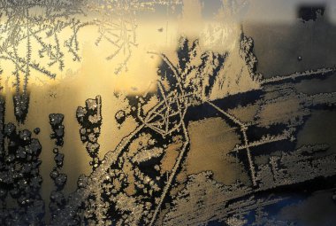 Kışın cam üzerinde güneş ışığında parlayan güzel buz deseni, doğal yakın plan arka plan ya da doku