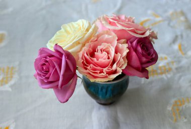 Zarif küçük buket güzel renkli güller beyaz örtüler üzerinde 