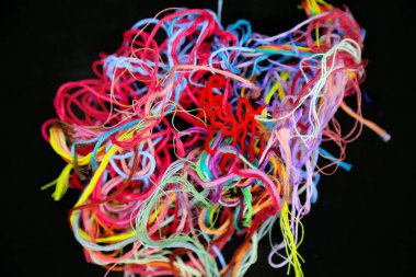 Çok renkli pamuklu iplik yumağı ve siyah arkaplanda örgü işi için iplik.