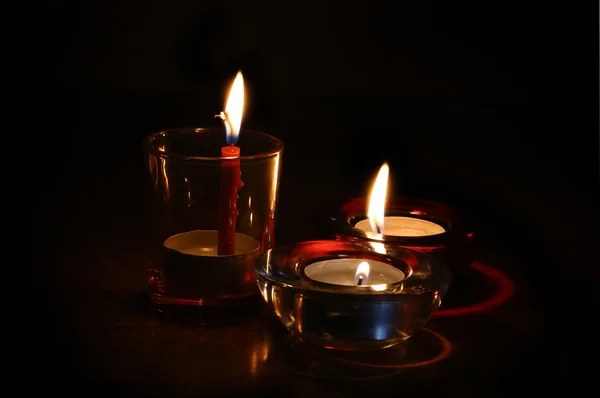 Tres velas encendidas en la oscuridad — Foto de Stock