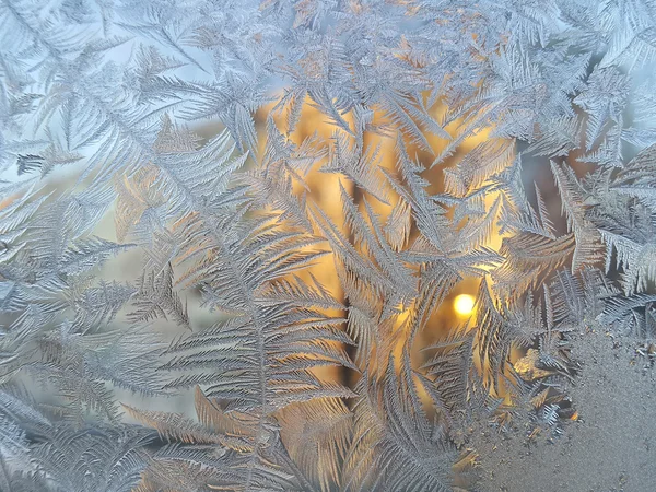 Ice pattern and sunlight on winter glass — Stock Photo, Image