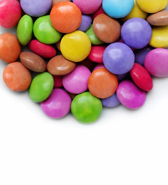 Білий фон з яскравими кольоровими цукерками — стокове фото