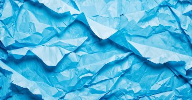 Kırışmış ve yırtılmış kağıdın mavi arka planı. Tasarım için doku.