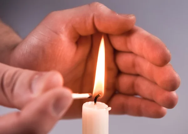 Ruce zapalovat svíčka — Stock fotografie