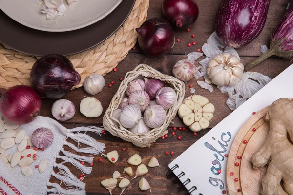 Knoblauch und Zwiebeln auf einem Holztisch — Stockfoto