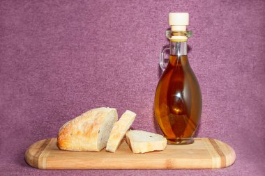 Zeytinyağı ve dilimlenmiş ekmek kesme tahtası üzerinde