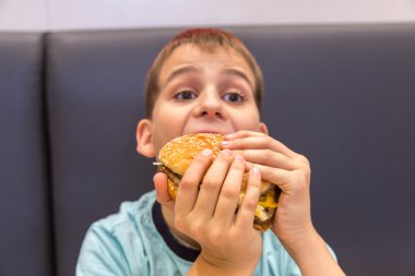 Sevimli çocuk hamburger yiyor