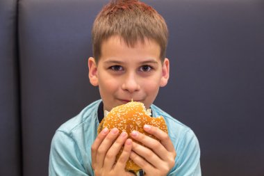 Sevimli çocuk hamburger yiyor