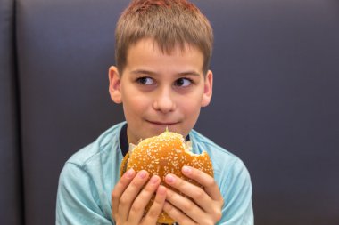 Sevimli çocuk hamburger yiyor