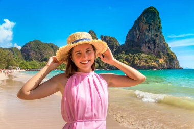 Tropikal Railay Sahili, Yengeç, Tayland 'da pembe elbise ve hasır şapka giyen güzel bir kadın.