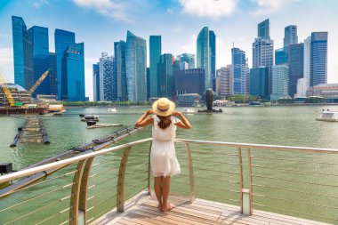 Güneşli bir günde güzel Singapur şehrine bakan bir kadın gezgin.