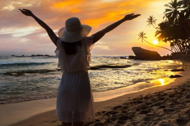 Sri Lanka 'daki Dalawella plajında Sunset' e bakan bir kadın.