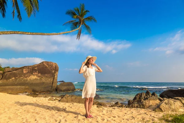 海の近くの熱帯のビーチに滞在帽子と白いドレスを身に着けている若い美しい女性の肖像画 — ストック写真