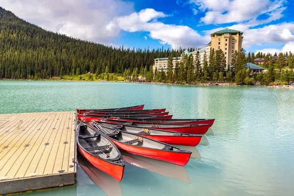 stock image LAKE LOUISE, CANADA - APRIL 2, 2020: Canoes on Lake Louise and hotel Fairmont Chateau Lake Louise, Banff National Park Of Canada