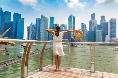 Güneşli bir günde güzel Singapur şehrine bakan bir kadın gezgin.