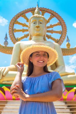 Koh Samui, Tayland 'da Büyük Buda' da mavi elbise ve hasır şapka giyen bir kadın gezgin.