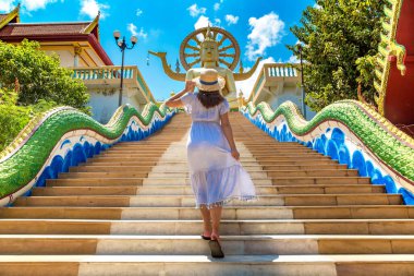 Koh Samui, Tayland 'da Büyük Buda' da mavi elbise ve hasır şapka giyen bir kadın gezgin.