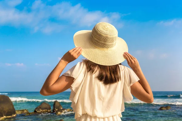 海の近くの熱帯のビーチに滞在帽子と白いドレスを身に着けている若い美しい女性の肖像画 — ストック写真