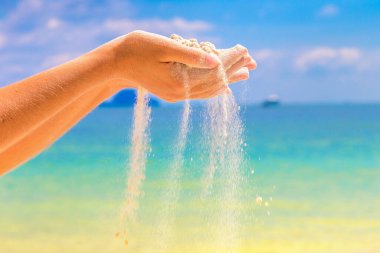 Tropik plajda kadınların ellerinden dökülen beyaz kum