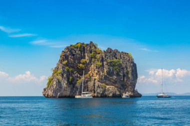 Sürat teknesi ve turistler Koh Haa Adaları yakınlarındaki tropikal bir denizde şnorkelle yüzüyorlar.