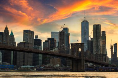 Brooklyn Köprüsü 'nün günbatımı ve New York City, ABD' deki Manhattan şehir merkezinin panoramik manzarası.