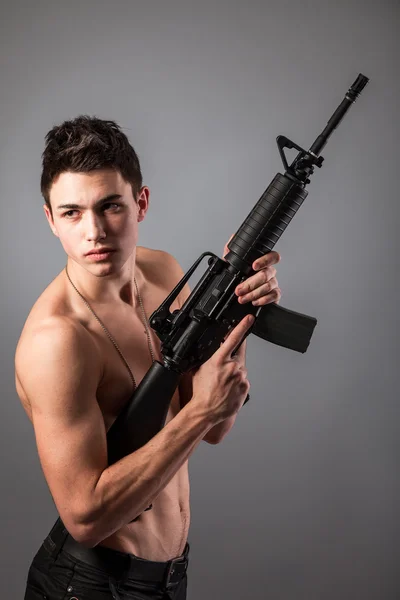 Голый солдат с винтовкой — стоковое фото