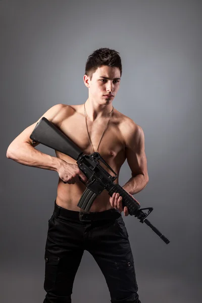 Bare-chested soldier with rifle — Stock Photo, Image
