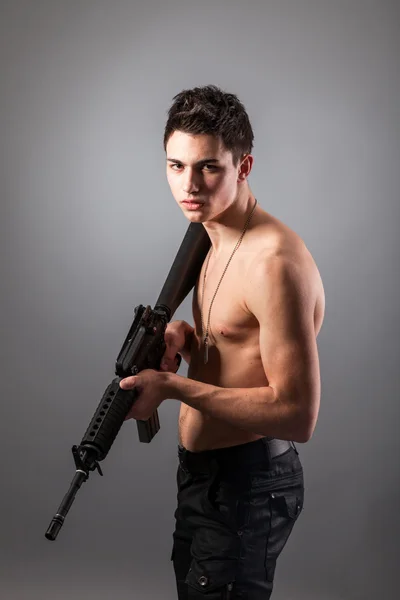 Bare-chested soldier with rifle — Stock Photo, Image