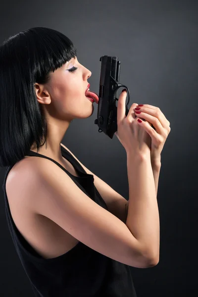 Woman licking gun — Stock Photo, Image