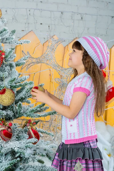 Klein meisje is kerstboom versieren — Stockfoto