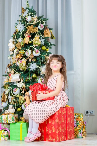 Ευτυχισμένη κοριτσάκι με τα Χριστούγεννα παρουσιάσουν χαμογελώντας — Φωτογραφία Αρχείου