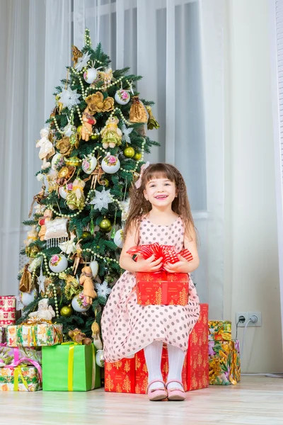 Счастливая маленькая девочка с рождественским подарком улыбается — стоковое фото