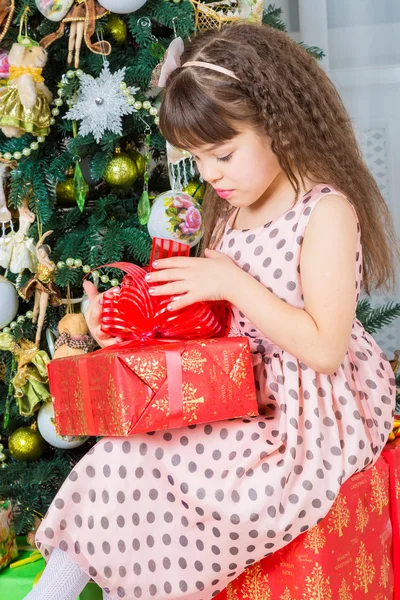 Glückliches kleines Mädchen mit Weihnachtsgeschenk lächelnd — Stockfoto