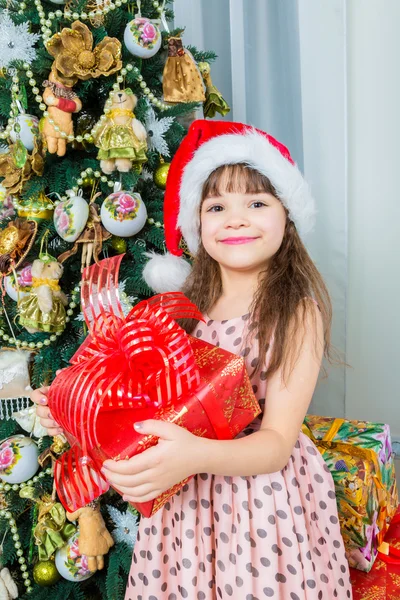 Happy little girl with christmas present smiling — Stock Photo, Image