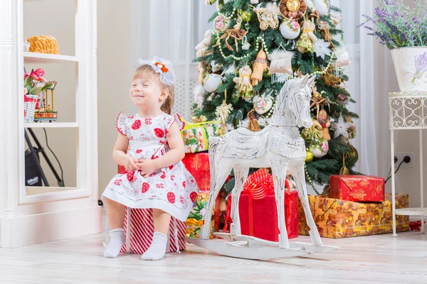 Bambina accanto a un cavallo a dondolo — Foto Stock