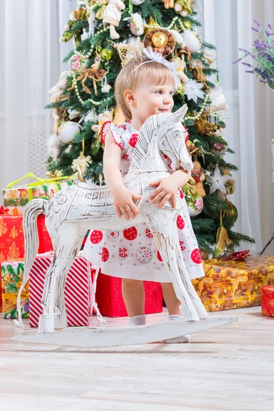 Bambina accanto a un cavallo a dondolo — Foto Stock