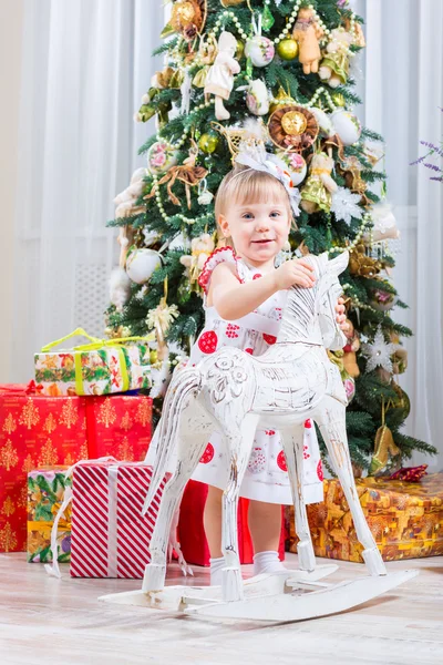 Bambina accanto a un cavallo a dondolo — Foto Stock