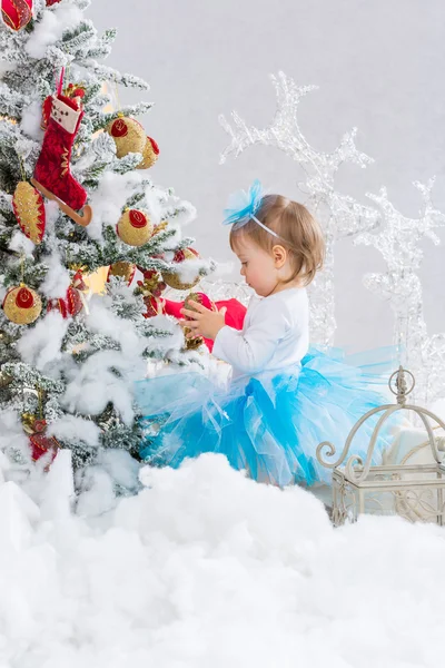 Klein meisje is kerstboom versieren — Stockfoto