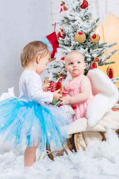 Little baby girls with gifts under the Christmas tree — Stock Photo, Image